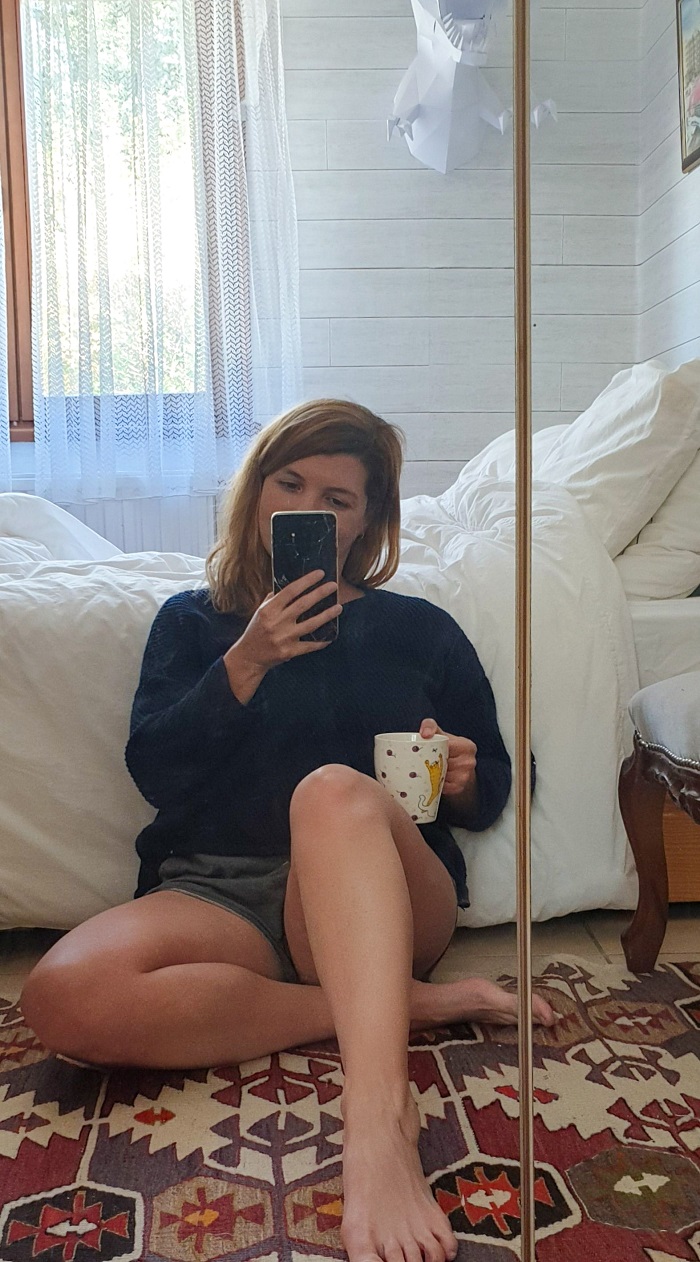 girl drinking tea taking mirror selfie